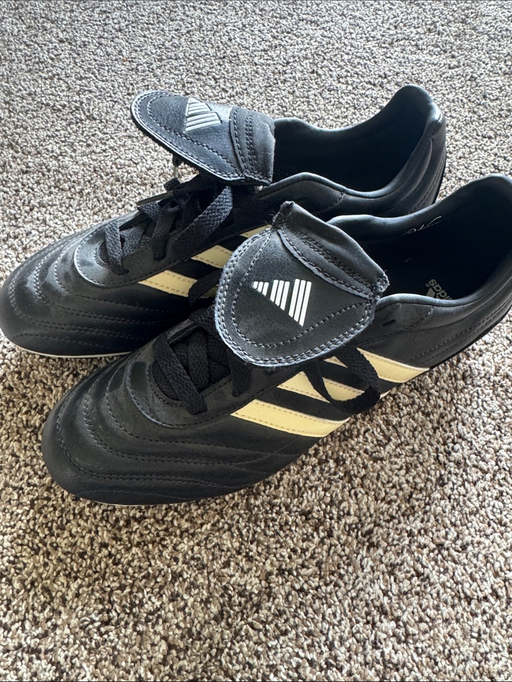 adidas women’s Black soccer Cleats with White Stripes